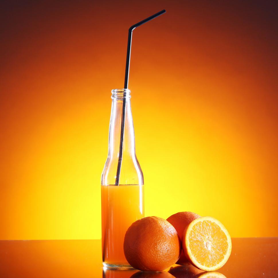 Free Image of Fresh orange drink in tall bottle with straw 
