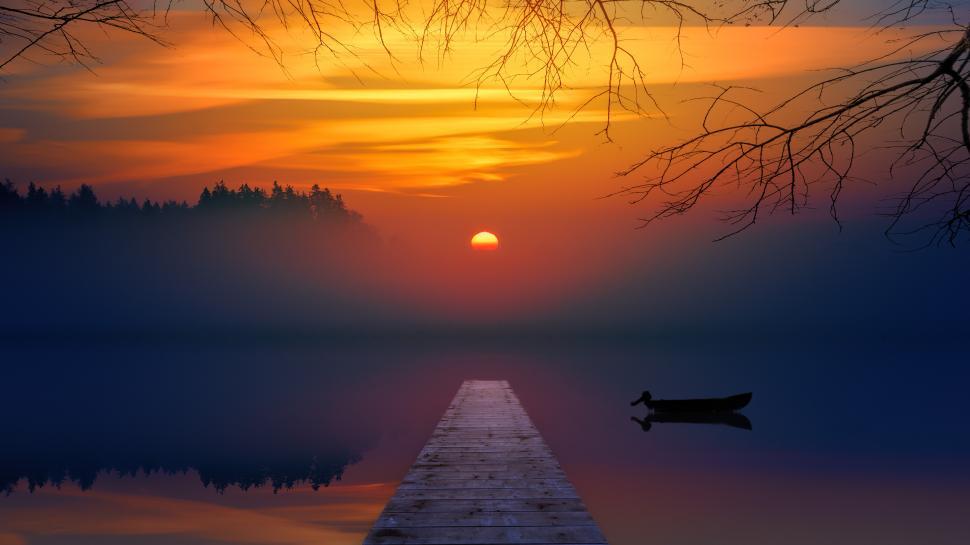 Free Image of Foggy view of lake with boat and orange sunset 