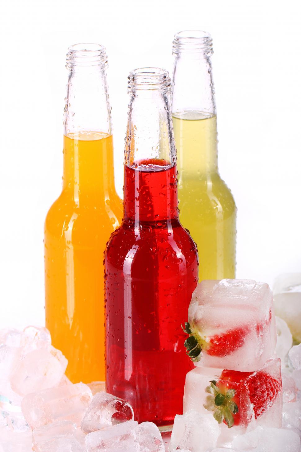 Free Image of Bottles with colorful beverages and fruit filled ice 