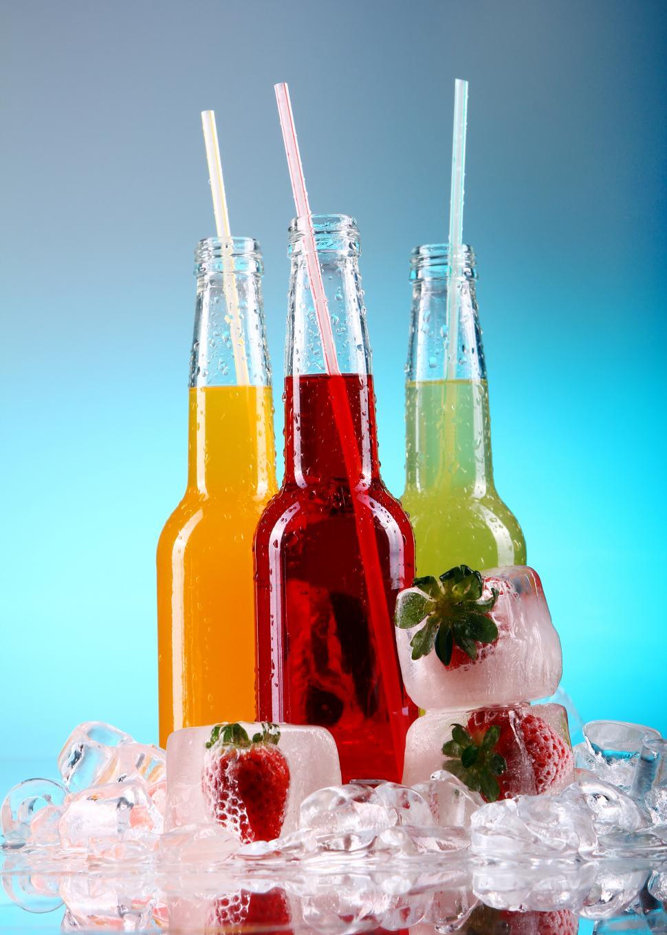Free Image of Colorful drinks with straws over blue background 
