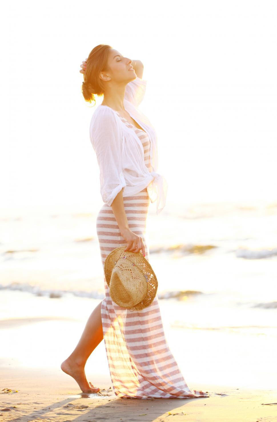 Free Image of Relaxed woman walks on the beach at sunset 