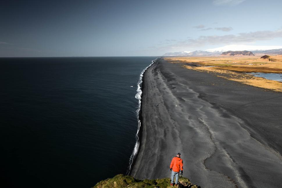 Free Image of Hiker and black sand beach 