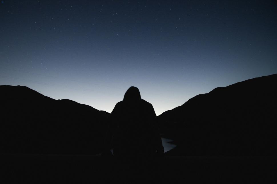 Free Image of Rear view of man and mountains with night sky 