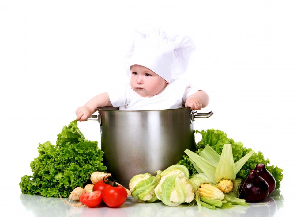 Free Image of Cute baby chef in a big pot with vegetables 