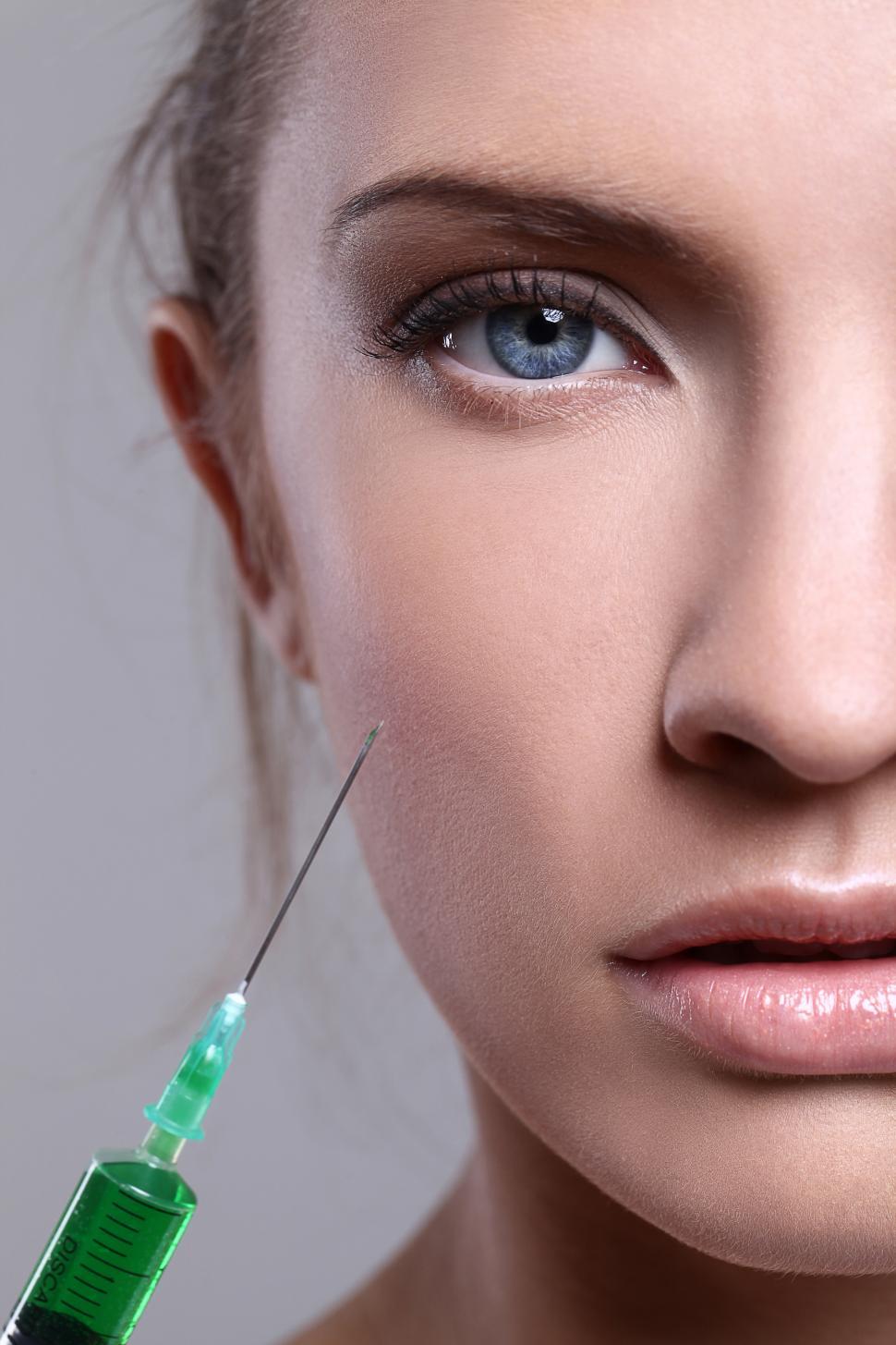 Free Image of A syringe and a female face - cosmetic procedure 
