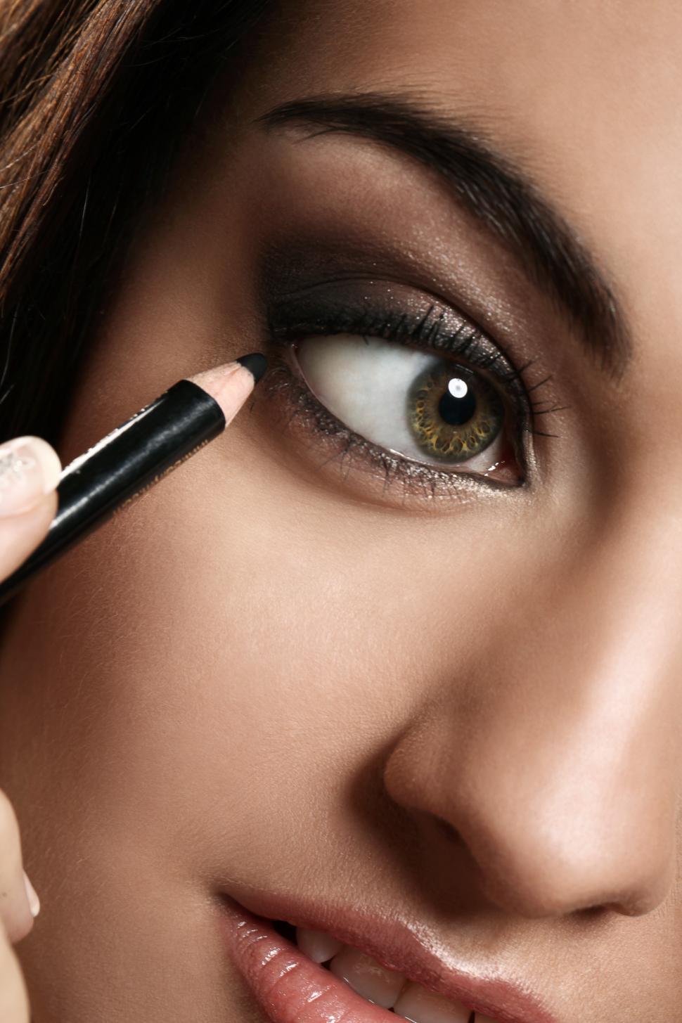 Free Image of Woman applying eye make, eyeliner 
