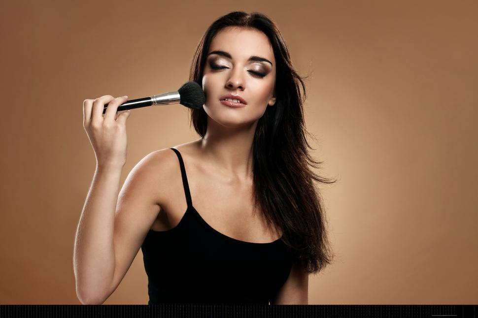 Free Image of Woman applying make up with large brush 