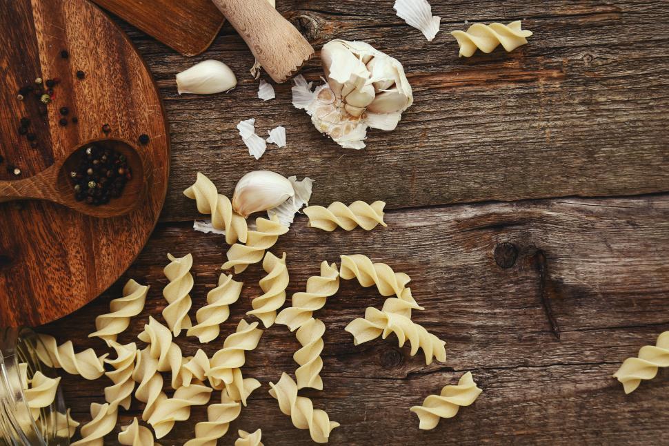 Free Image of Pasta, garlic on a textured wooden table 