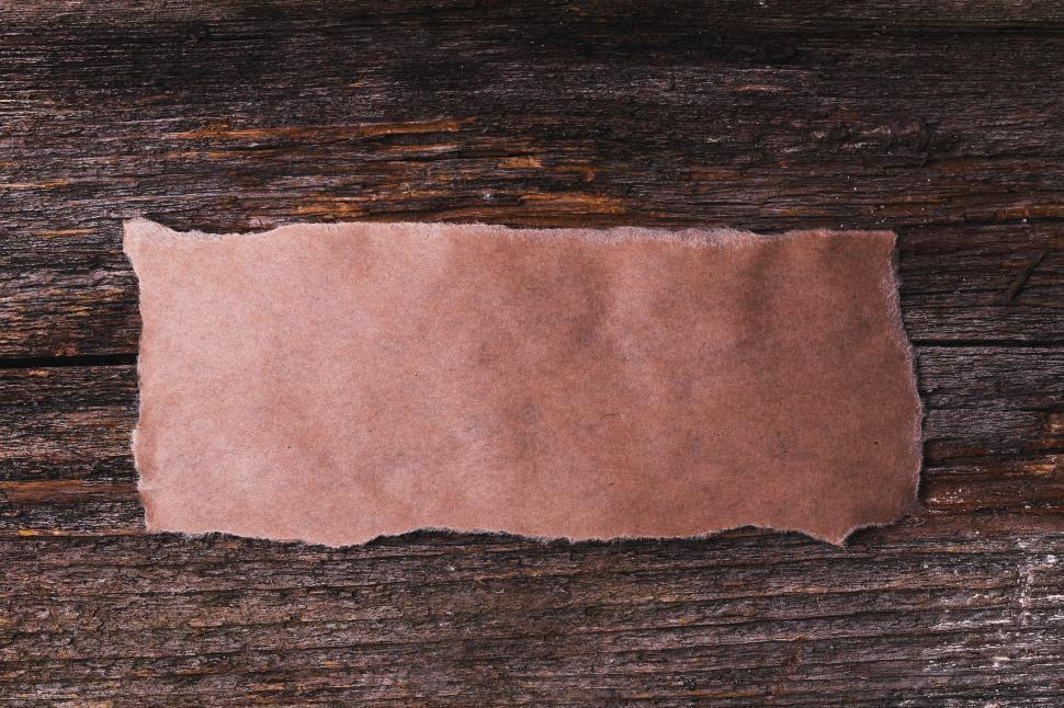 Download Free Stock Photo of Blank rectangle of torn paper on rough wooden background 