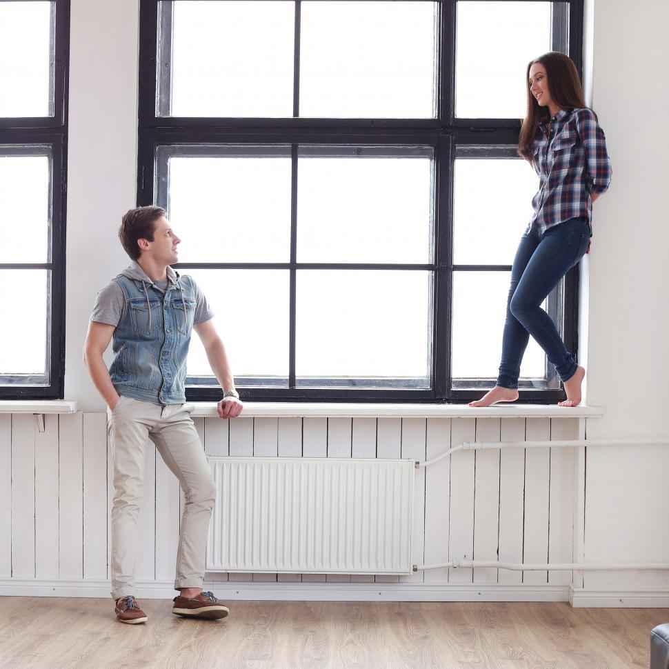 Free Image of Couple at home, standing at the window 