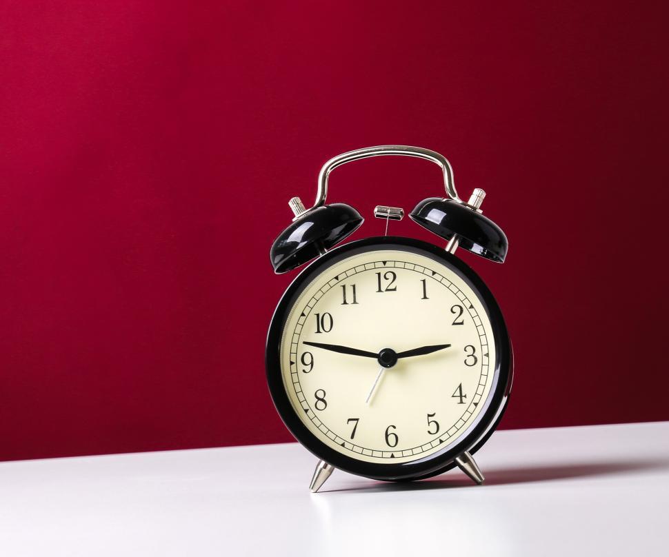 Free Image of Vintage style alarm clock on crimson background 
