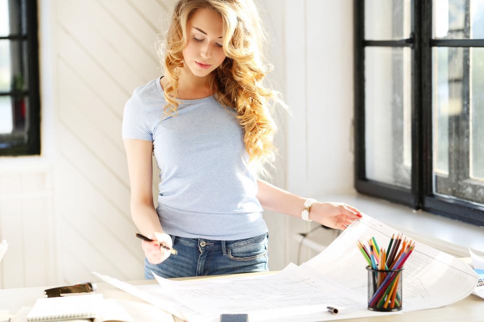 Free Image of Woman working on architectural plans 
