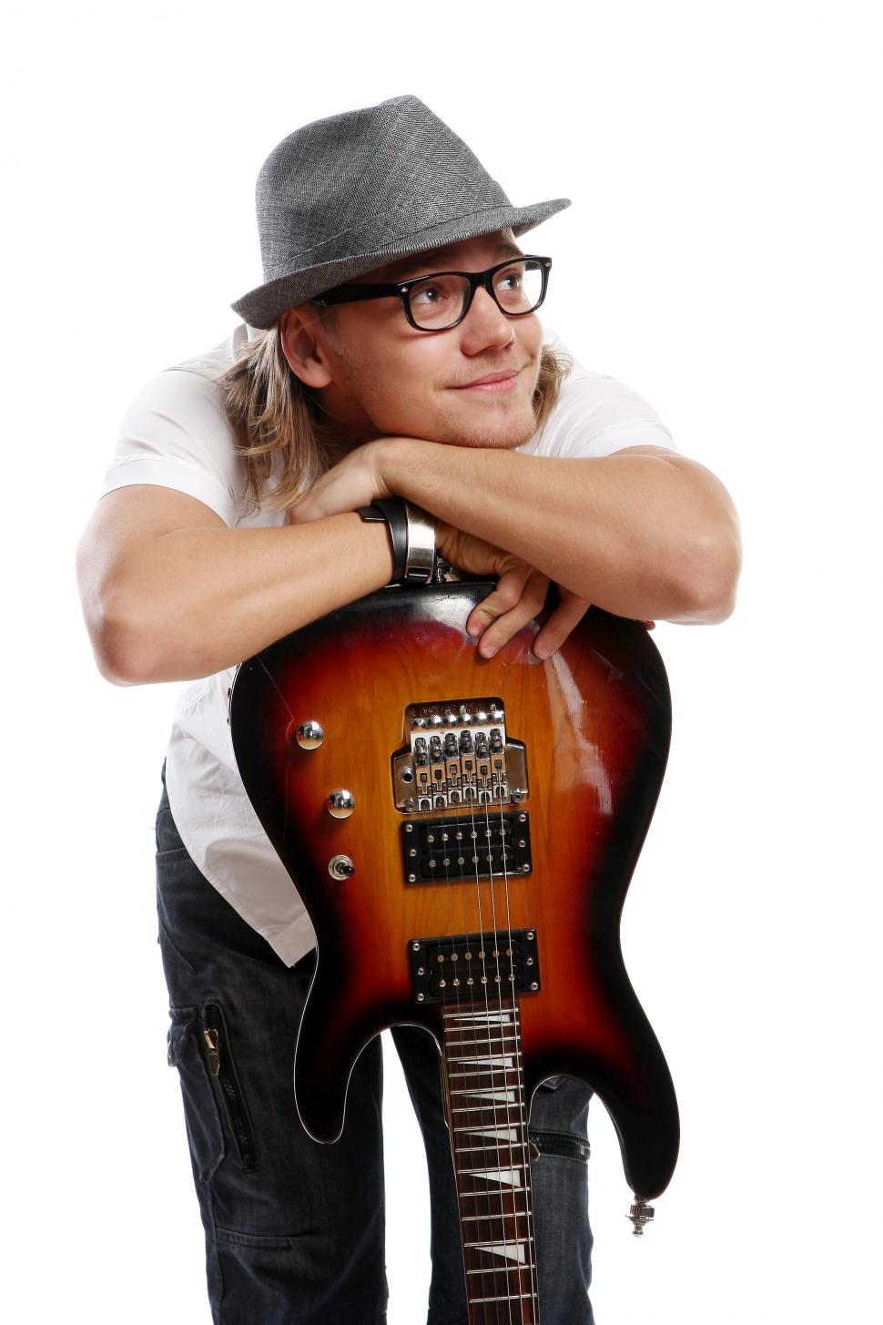 Free Image of a young musician leaning on an electric guitar 