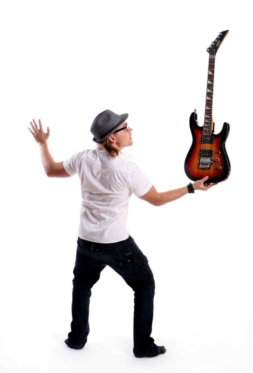 Free Image of Musician balancing a guitar 