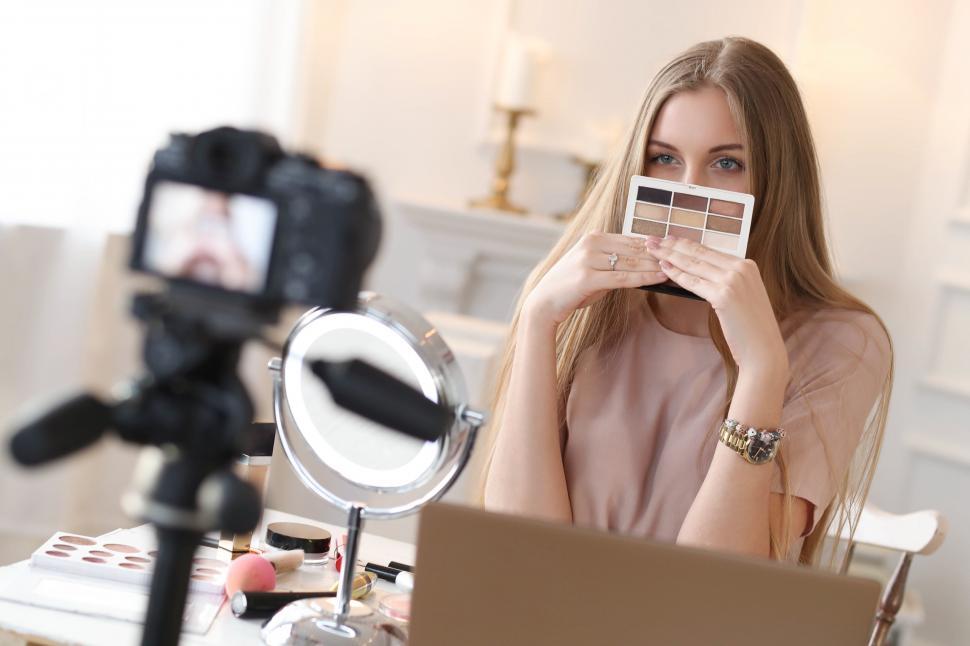 Free Image of Beauty blogger showing product 
