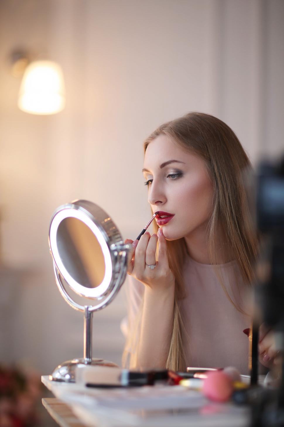 Free Image of Beauty blogger applying lip color 