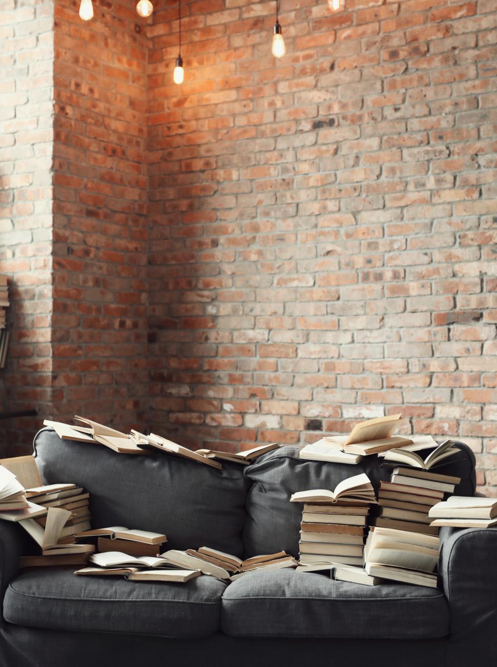 Free Image of Couch covered in books 