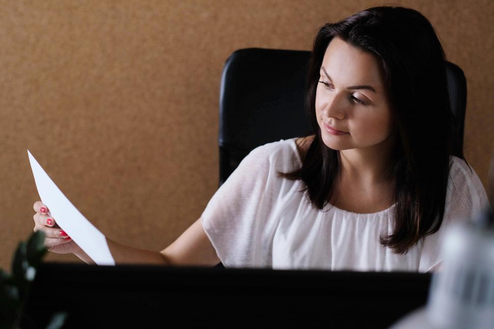 Free Image of Woman looking over paperwork 