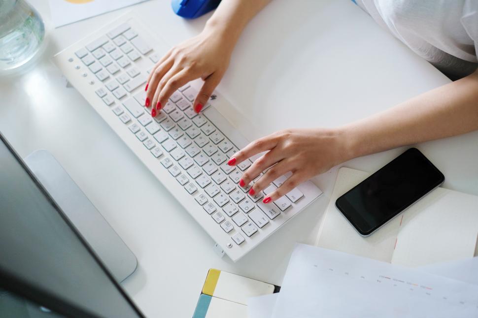 Free Image of Woman with red nails typing 