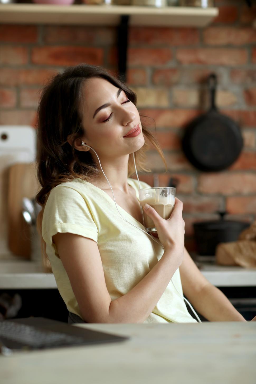 Free Image of Woman listening to music in kitchen 