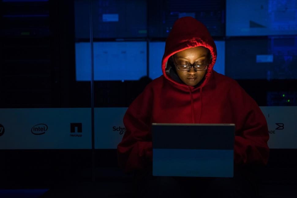 Free Image of Woman engineer with laptop and red hoodie - In Data Center 