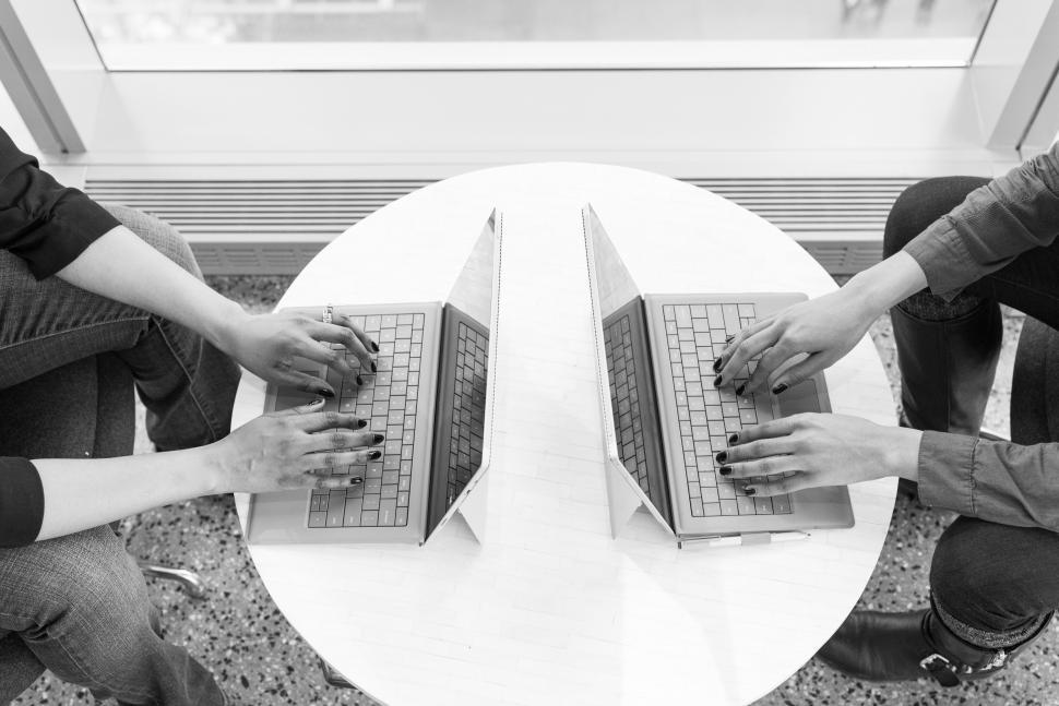Free Image of Female co-workers hands with laptops - b&w 