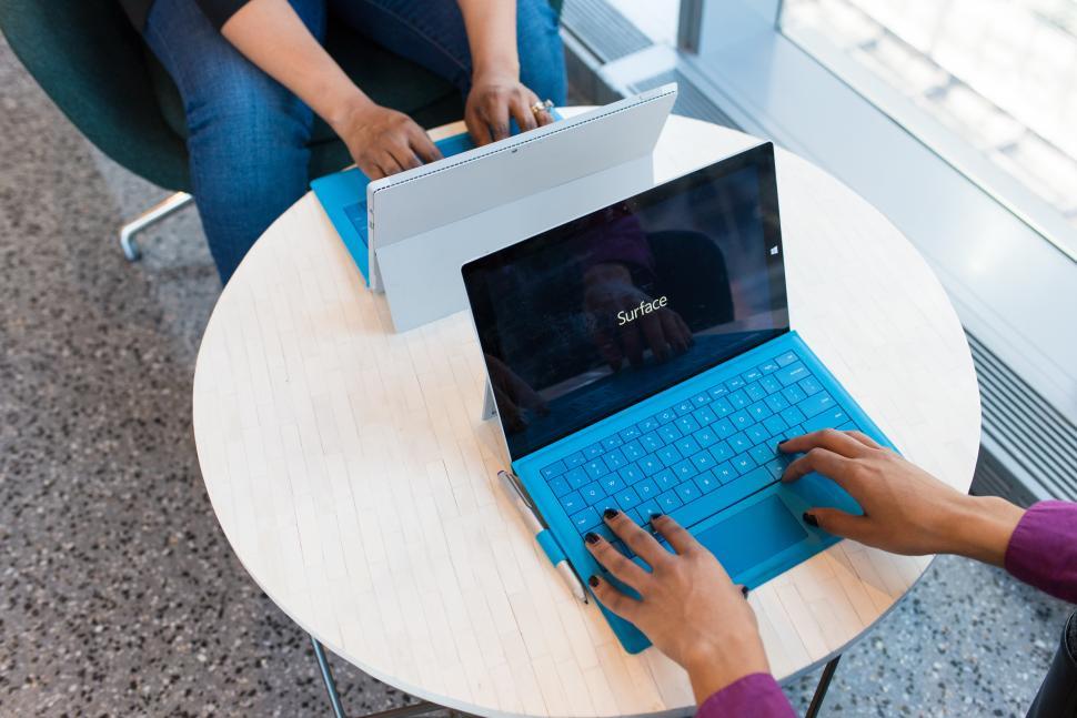 Free Image of Female co-workers hands with blue laptops 