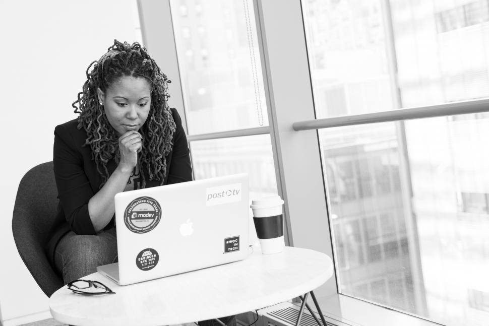 Free Image of Female programmer with laptop and disposable coffee cup - b&w 