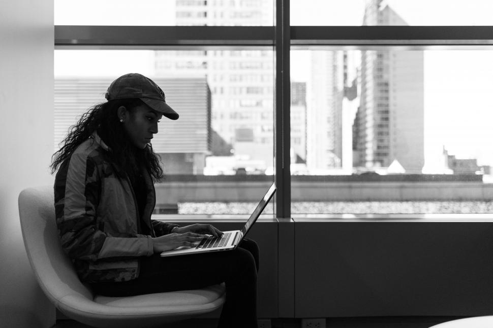 Free Image of Side view of stylish woman sitting with laptop 