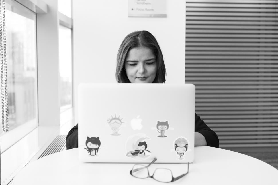 Free Image of Businesswoman working on laptop in office - b&w 