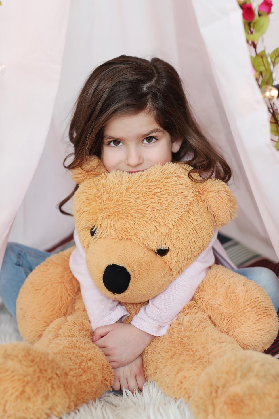 Free Image of Child hugging large teddy bear 