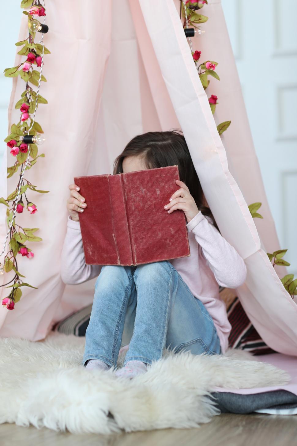 Free Image of Child with face buried in a book 