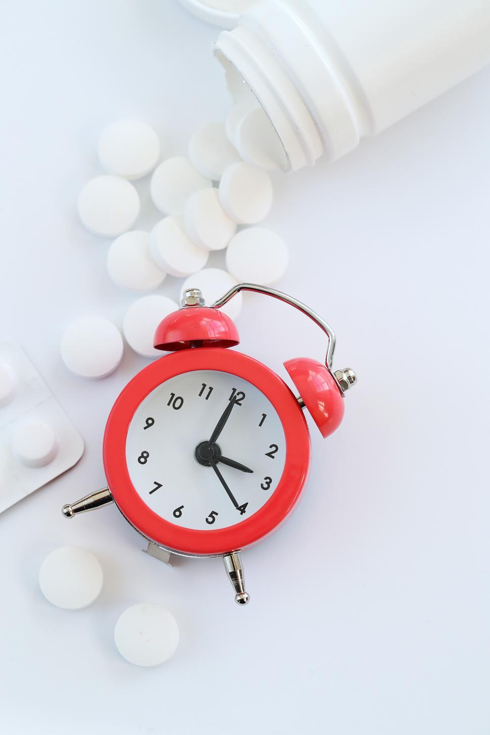 Free Image of Pharmaceutical. Drugs on the table with red clock 