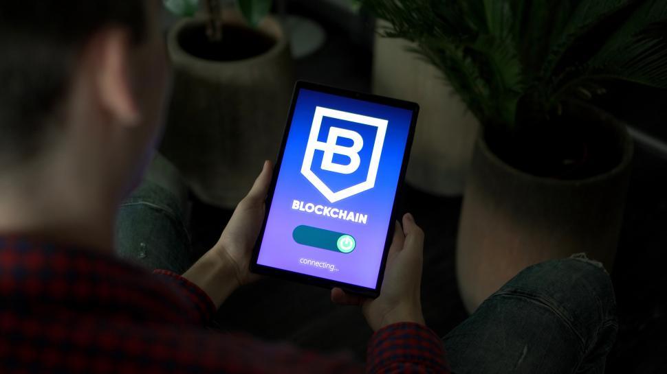 Free Image of Person Holding Cell Phone With Blockchain Logo 