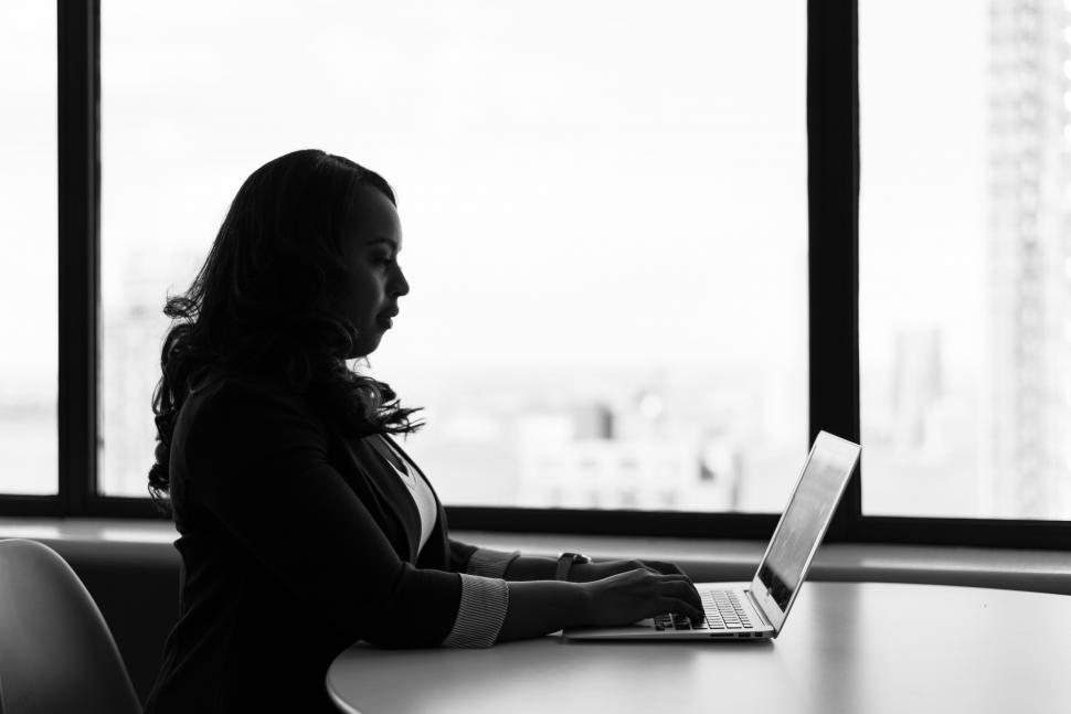 Free Image of Businesswoman sitting with laptop in office - b&w 