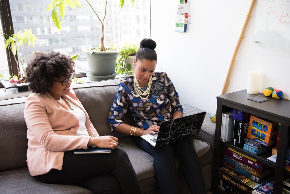 Free Image of Stylish female colleagues with laptop on couch 