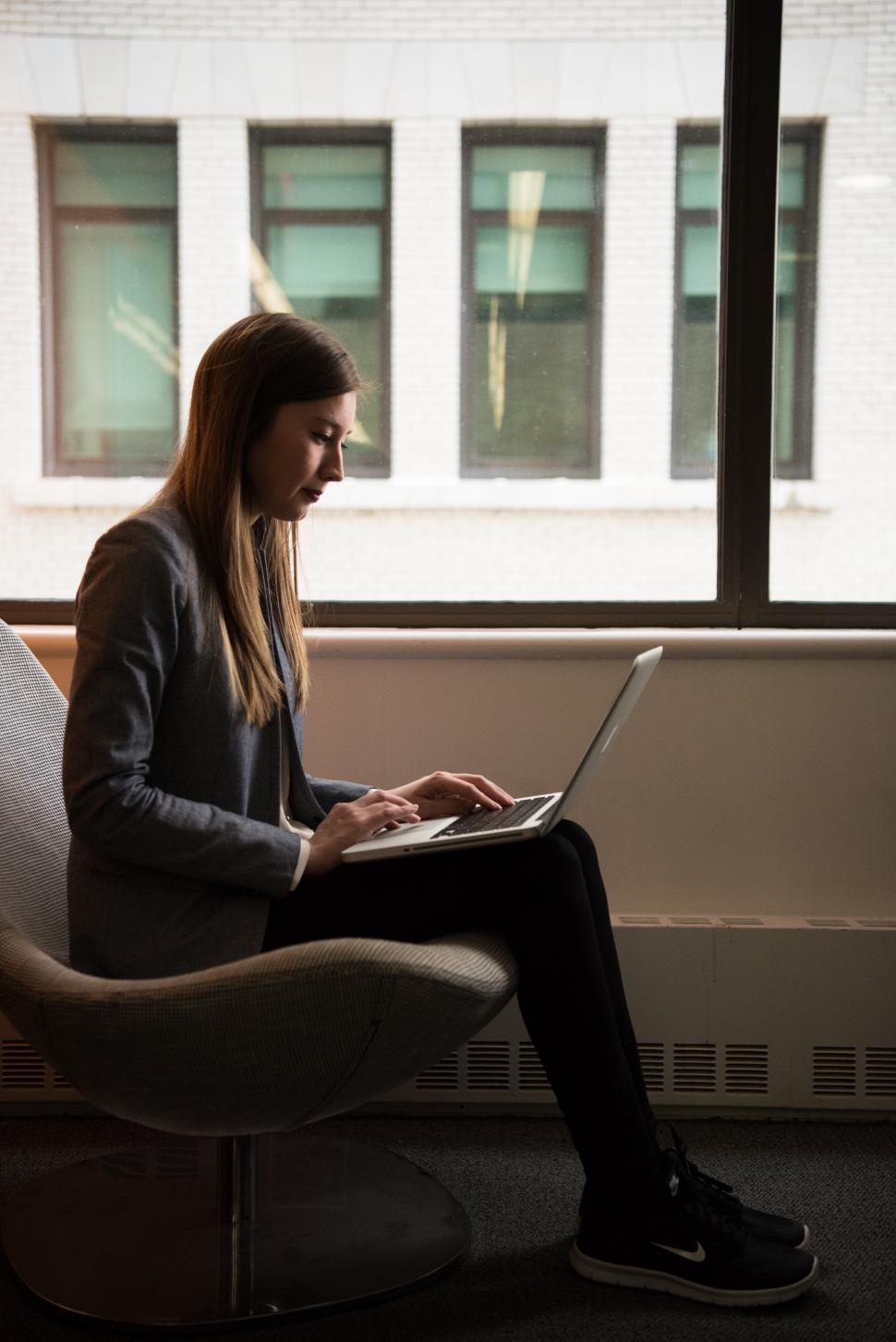 Free Image of Female using laptop near window in office 