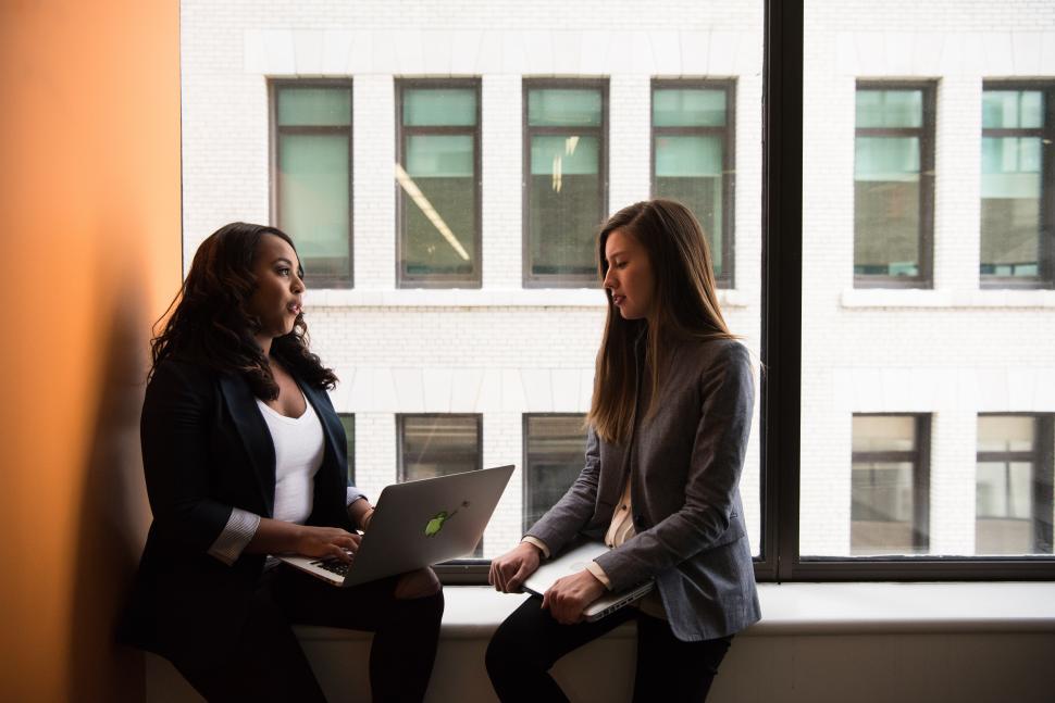Free Image of Businesswomen with laptop talking to each other 