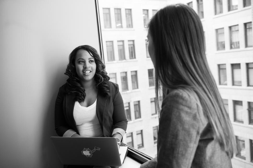 Free Image of Businesswomen talking to each other in office - b&w 