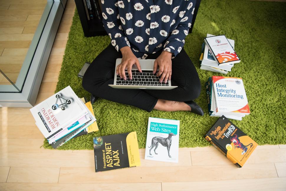 Free Image of Female developer with laptop and books 