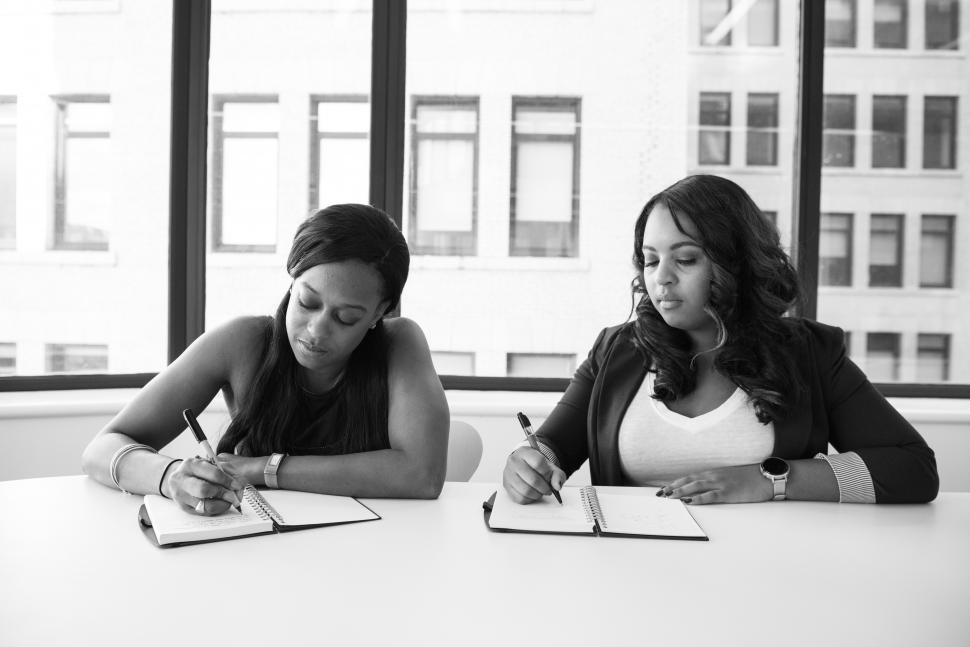 Free Image of Businesswomen writing notes with pen - b&w 