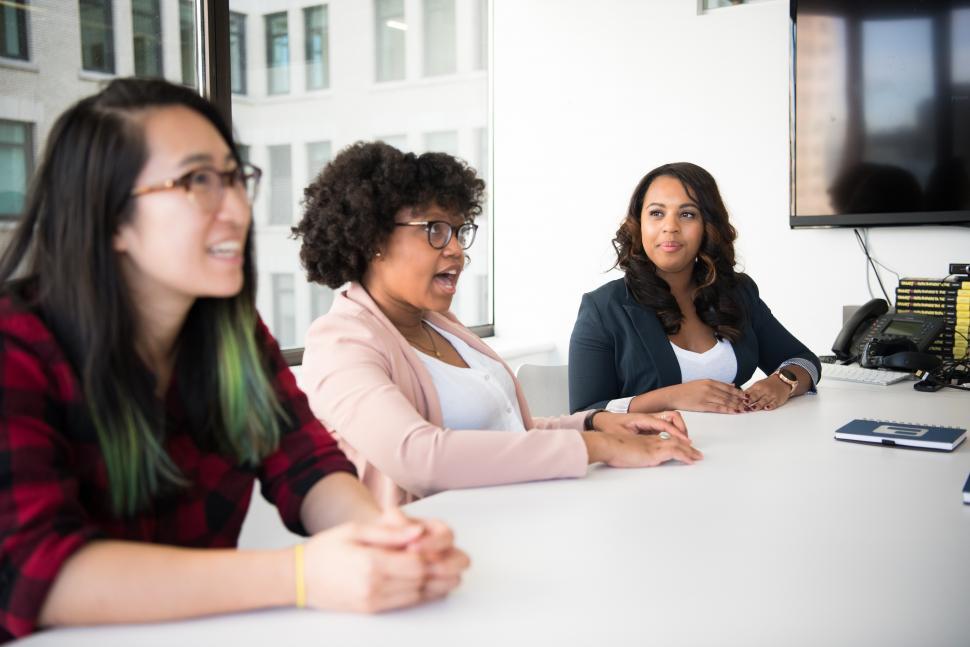 Free Image of Young female co-workers sitting in conference room 