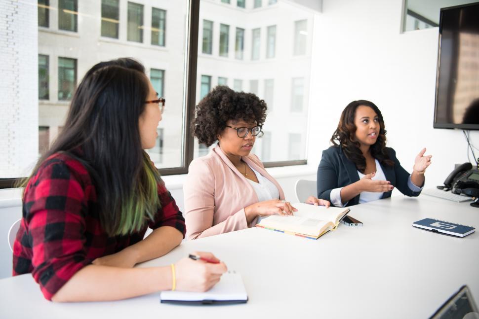 Free Image of Three young female co-workers sitting in conference room 