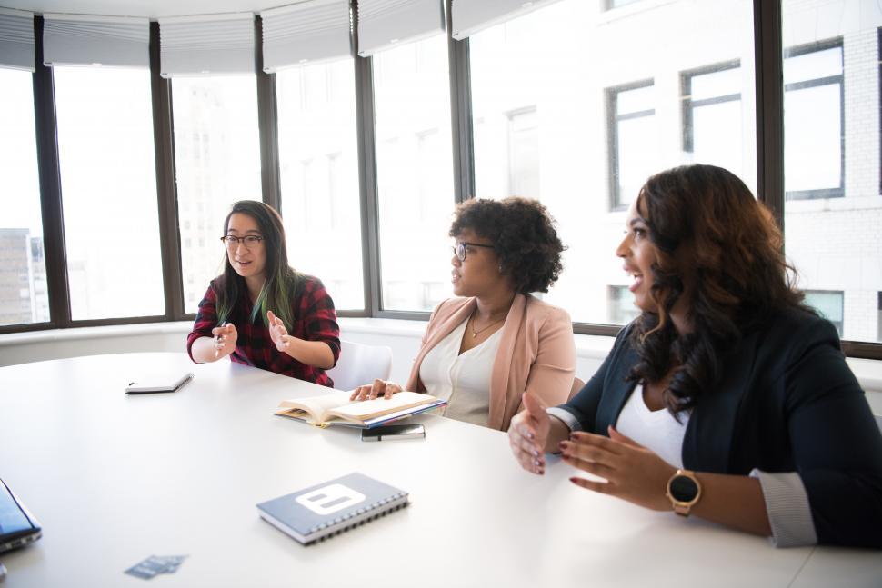 Free Image of Three young female colleagues sitting in a meeting room 