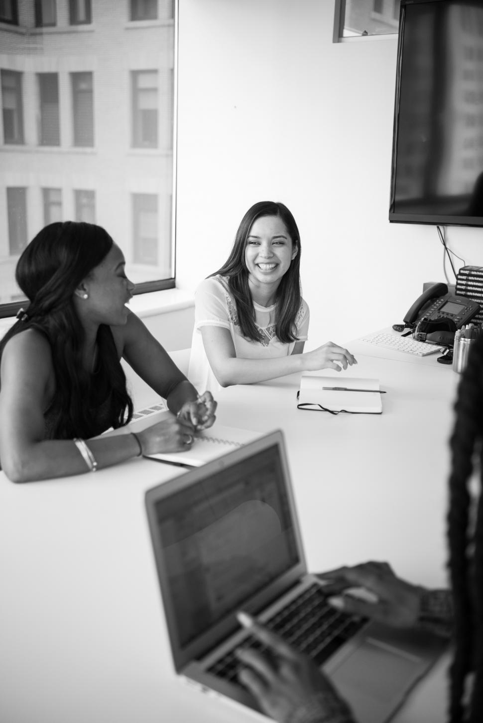 Free Image of Two businesswomen smiling in meeting - b&w 