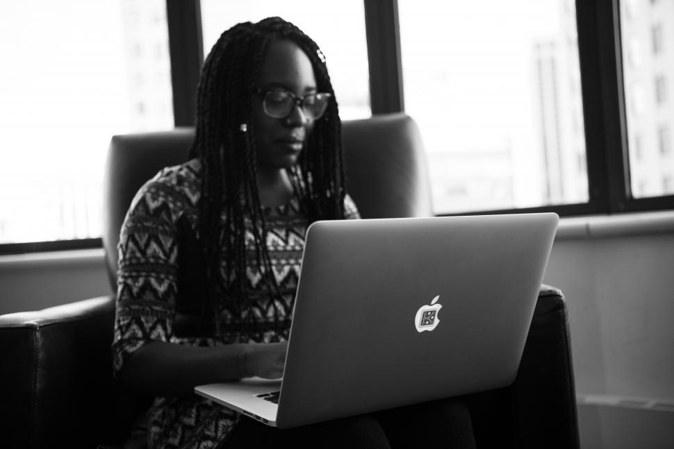 Free Image of Female programmer with laptop near window - b&w 
