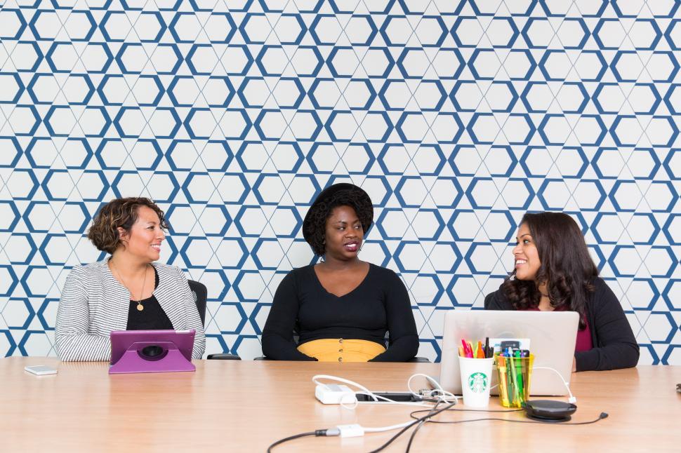 Free Image of Three female co-workers talking in meeting room 