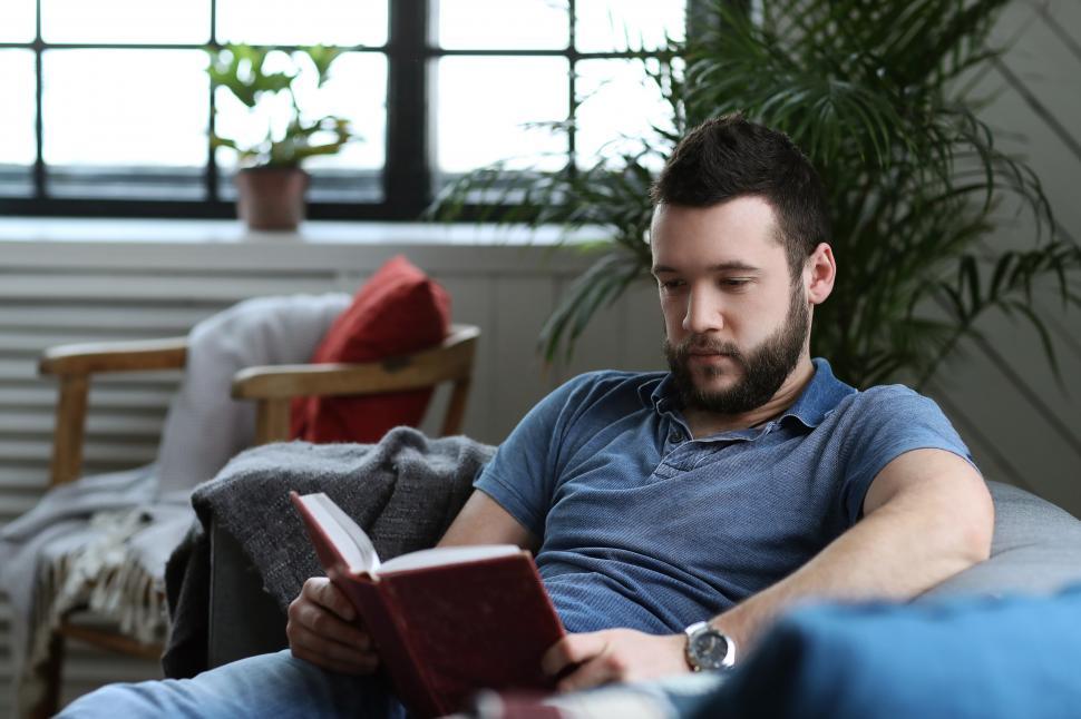 Free Image of Reading a book on the couch 