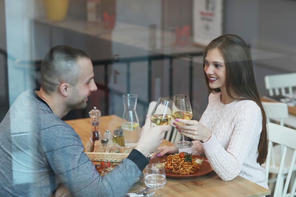 Free Image of Couple toasting at a table 