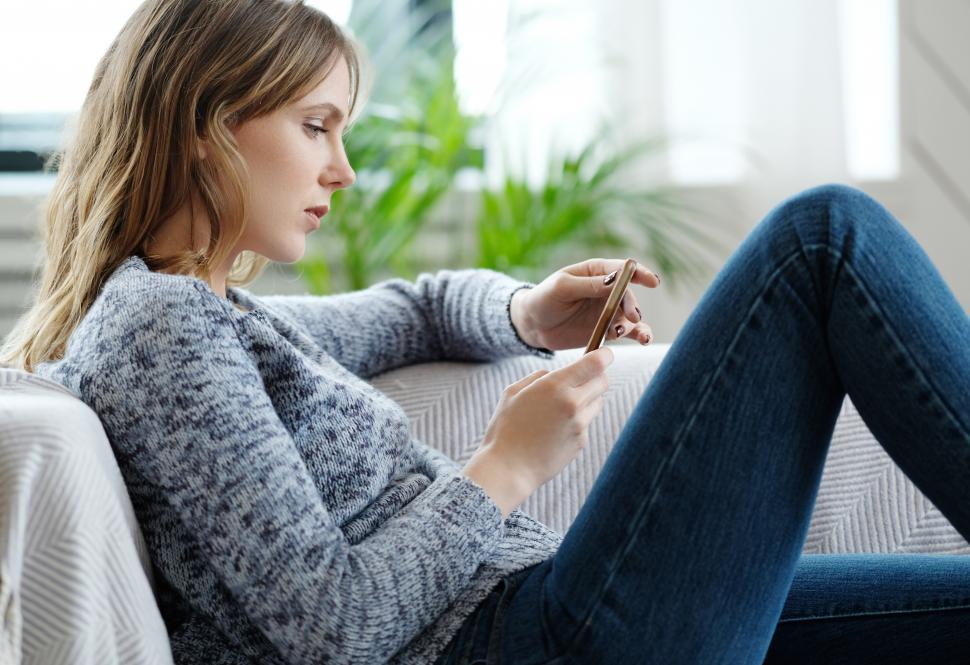 Free Image of Woman at home looking at her phone 